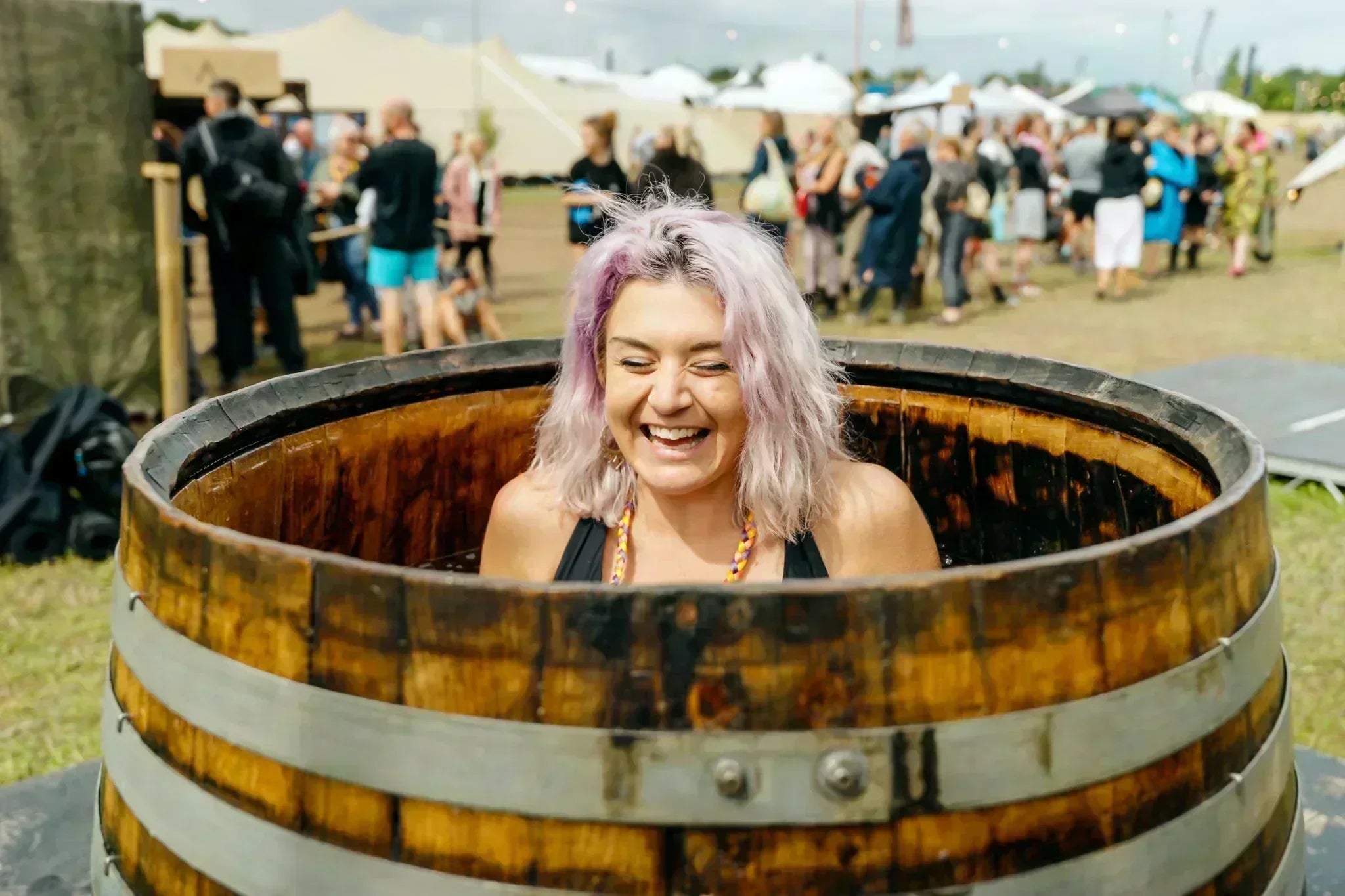 A woman laughs joyfully while immersed in cold plunge