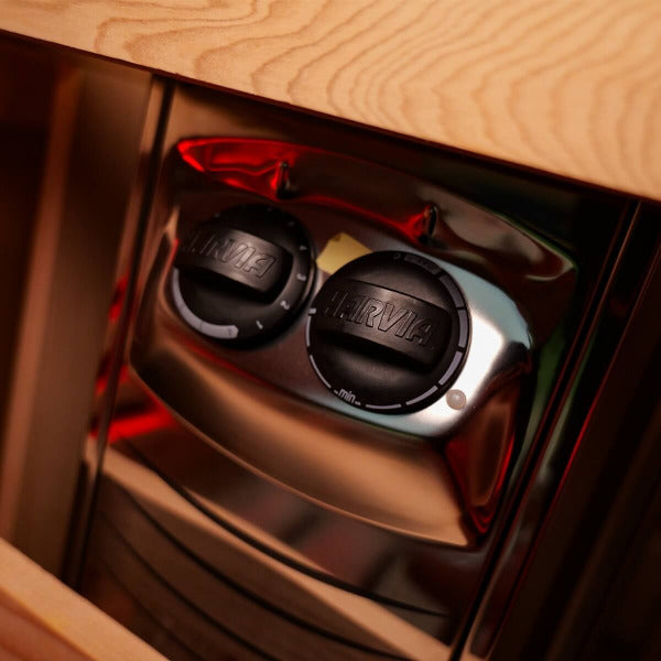 Close-up of Harvia sauna heater control dials inside wooden barrel sauna
