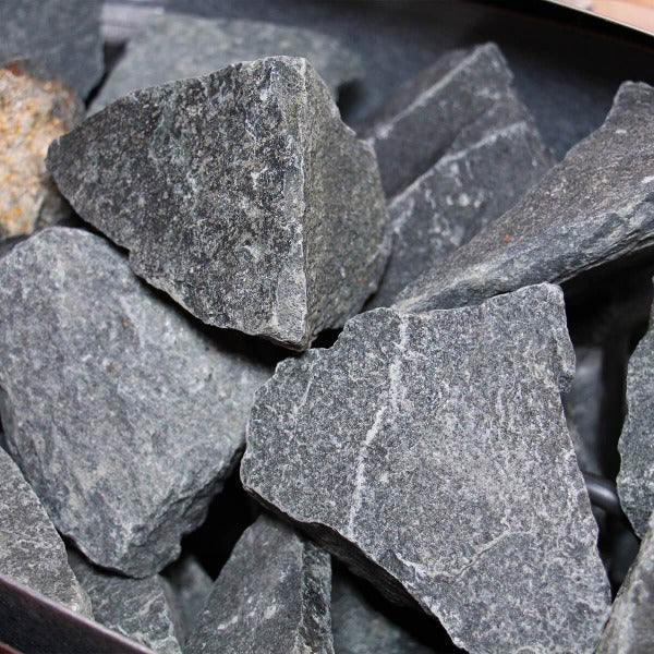 Close-up of grey sauna stones used for generating steam and heat.