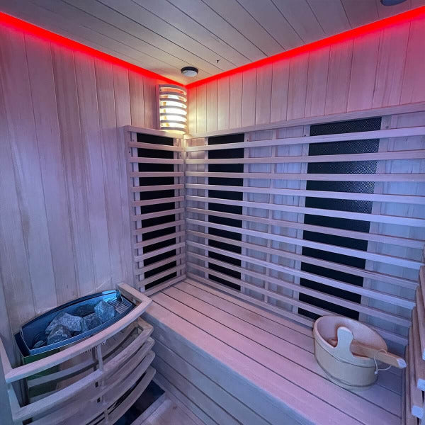 Sauna interior with bright wall lamp, wood slats and red LED perimeter lighting