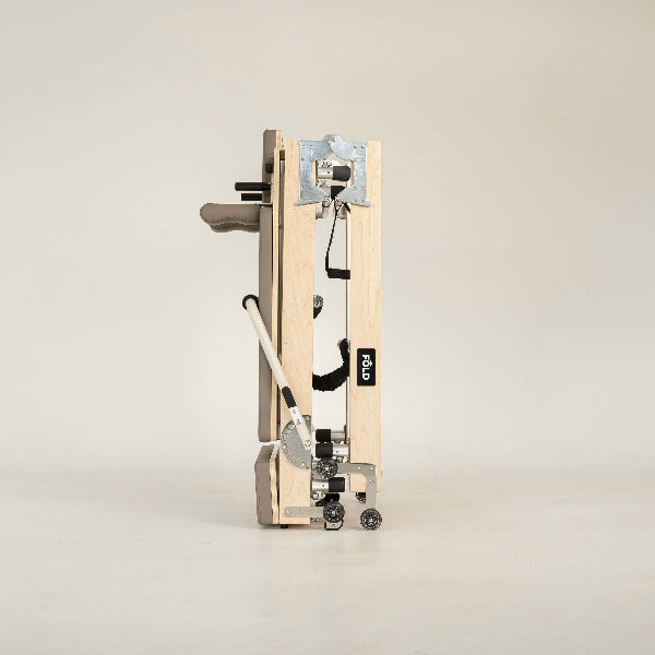 Mocha Pilates reformer side view highlighting foldable structure.