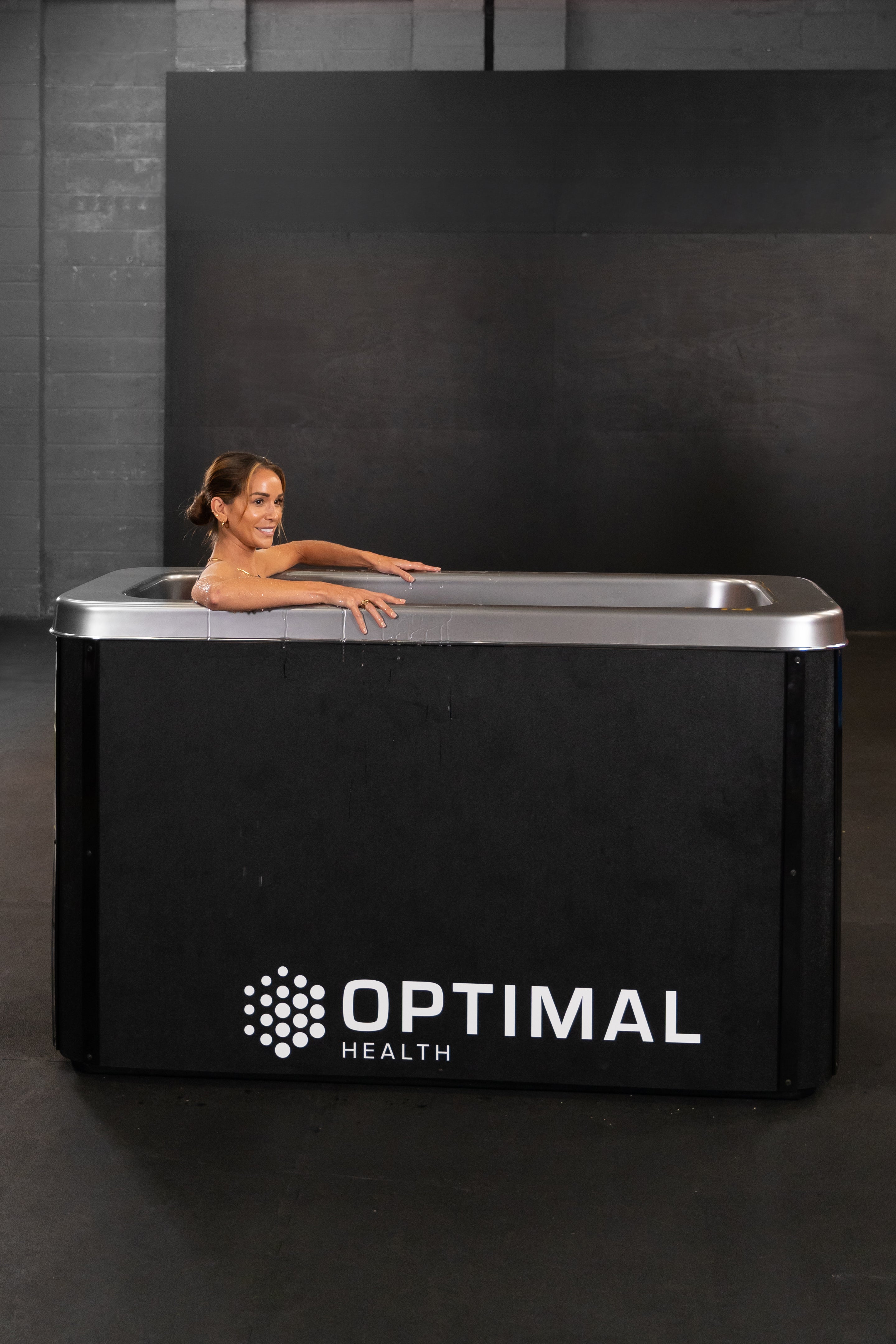 Woman smiling while submerged in Optimal Health Ice Bath.