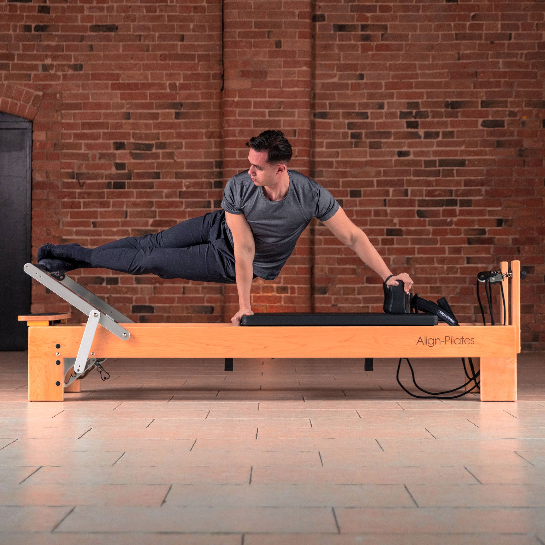 Align-Pilates M8-Pro maple wood Pilates reformer, angled view showing the oversized carriage and footbar