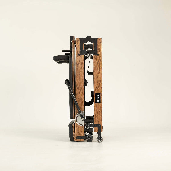 Black Pilates reformer side view with red oak wood frame and folding design.