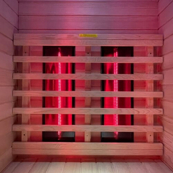 Rear infrared heater panels glowing red behind safety slats inside sauna