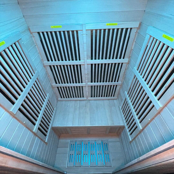 Internal view of Insignia infrared sauna showing wall heater panels under blue LED lighting