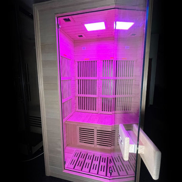 Full front view of Insignia KY004 infrared sauna illuminated with pink LED lights