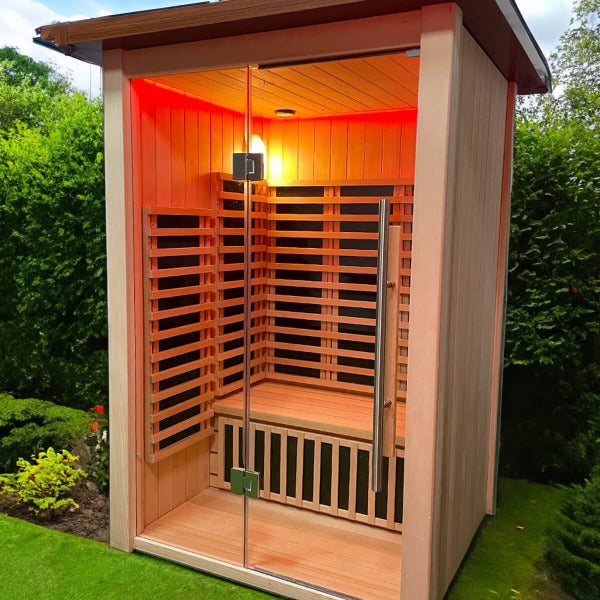 Outdoor 2 person sauna with red lighting and glass front door in garden setting