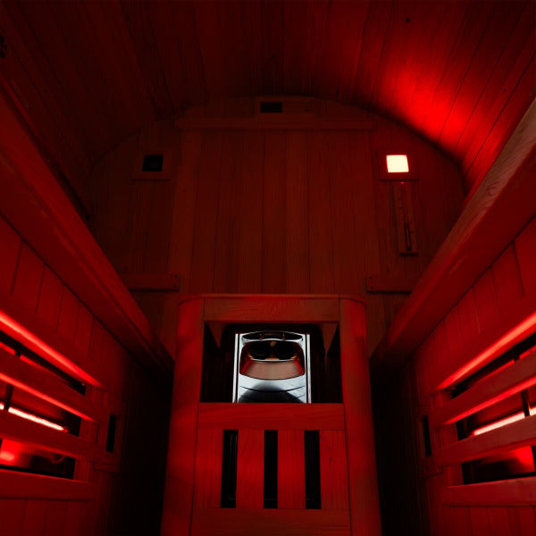 Inside view of hybrid barrel sauna with Harvia heater and red ambient lighting