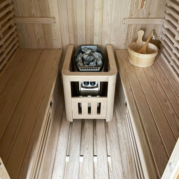Interior view of hybrid barrel sauna showing Harvia heater and wooden benches