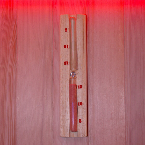 Wooden sauna sand timer mounted on wall with red sand and ambient lighting