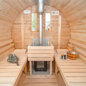 Interior of a wooden barrel sauna with benches and a central wood stove heater.