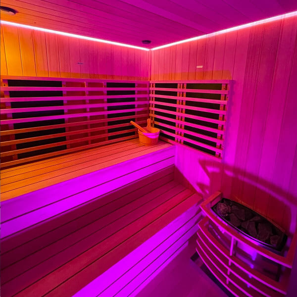 Top-down view of sauna benches and stove under purple chromatherapy lighting